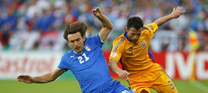 Italský záložník Andrea Pirlo (vlevo) a jeho rumunský protějšek Razvan Rat při vzájemném souboji.