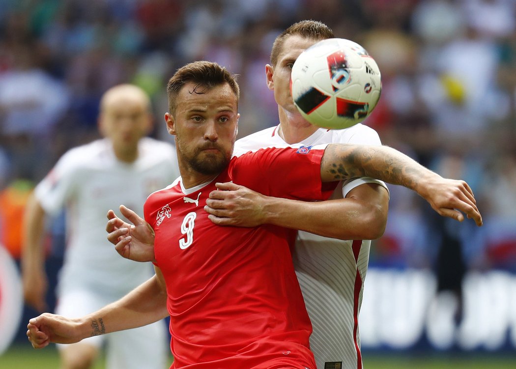 Švýcarský fotbalista Haris Seferovic v souboji o míč s Polákem Arturem Jedrzejczykem v osmifinále EURO 2016.