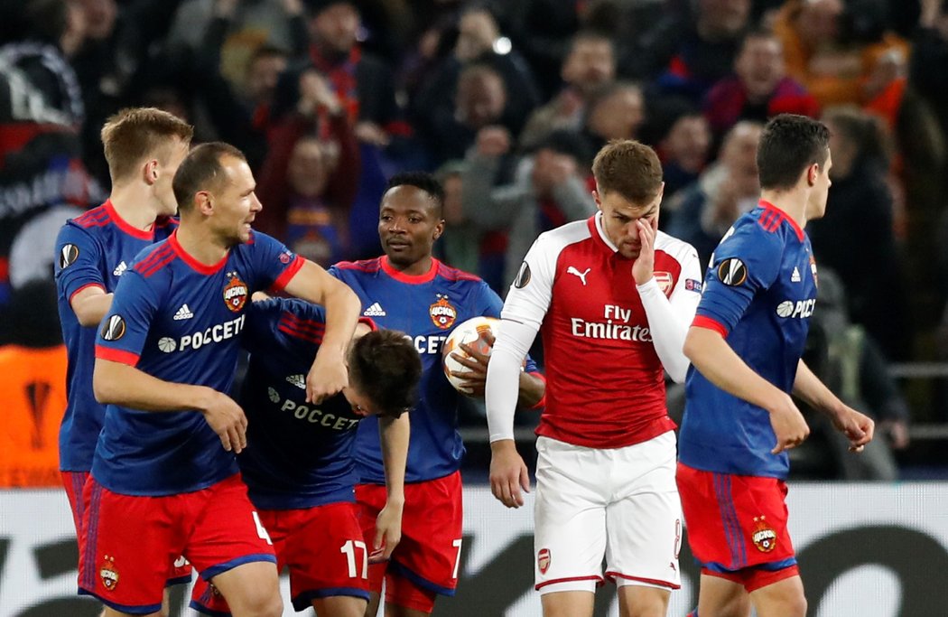 Fotbalisté CSKA Moskva se radují z druhé branky proti Arsenalu, před nimi smutní Aaron Ramsey