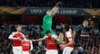 Petr Čech se snaží lapit míč v hloučku hráčů Arsenalu
