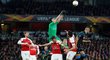 Petr Čech se snaží lapit míč v hloučku hráčů Arsenalu