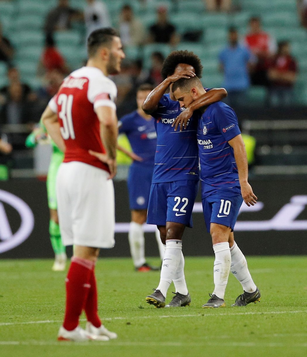 Smutný Sead Kolašinac. V pozadí slavící hráči Chelsea Wilian a Eden Hazard