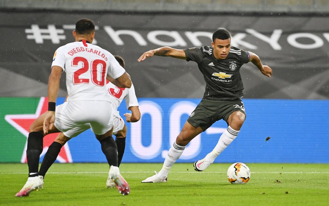 Mason Greenwood se snaží přejít přes bránící hráče Sevilly