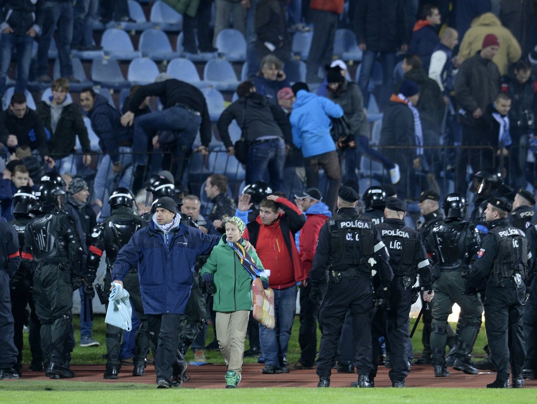 Obyčejní fanoušci prchali v obavách z tribuny, kde se odehrávaly potyčky rowdies Slovanu a Sparty, policejní těžkooděnci je hnali zpátky