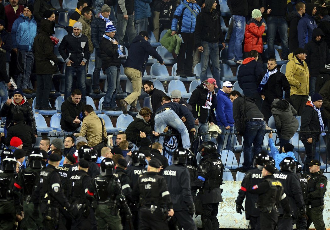 Zásahová policie zahání fanoušky zpět na tribunu, kde zuřily rvačky mezi rowdies obou klubů