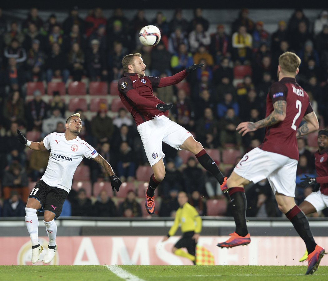 Sparťanský obránce Michal Kadlec odklízí nebezpečný centr Hapoelu