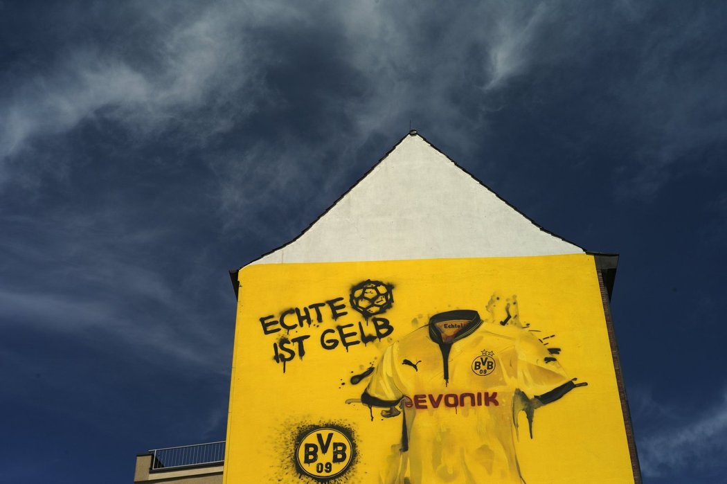 My jsme Borussia. Fanoušci fotbalového klubu z Dortmundu mocně povzbuzují svůj milovaný tým, někteří z nich si dokonce malují symboly klubu na fasádu od domu.