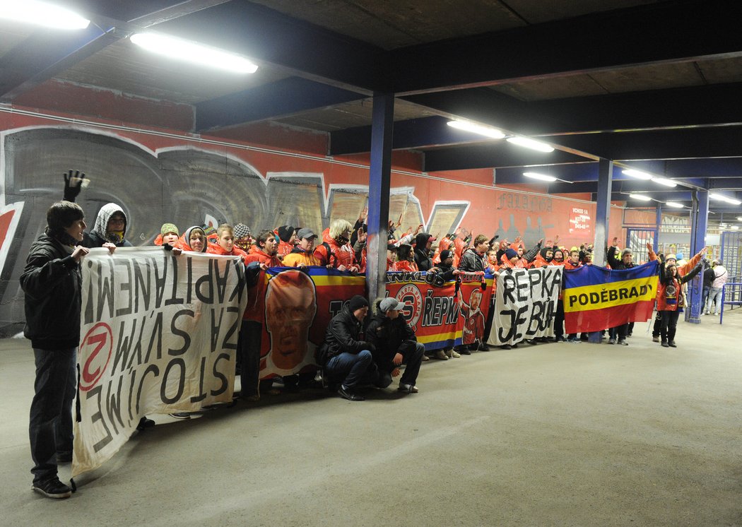 Sparťanští fanoušci pózující s transparenty před letenským stadionem