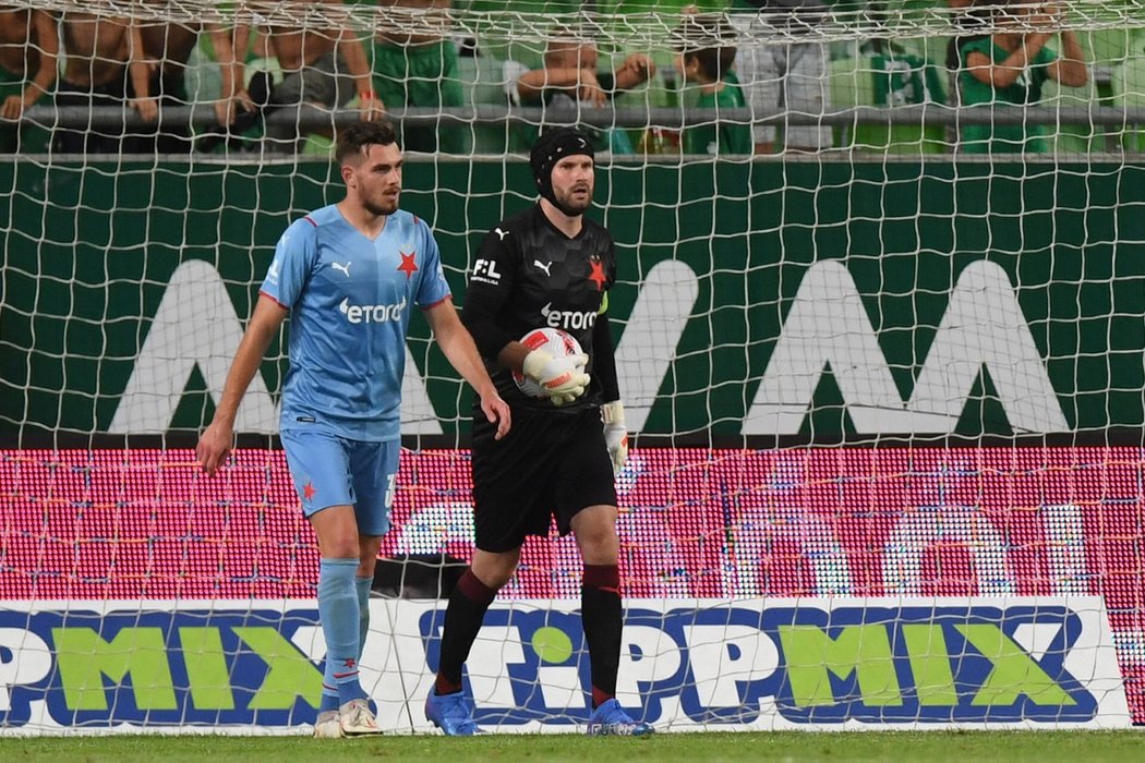 Gólman Ondřej Kolář loví balon ze sítě po vlastním gólu Tarase Kačaraby (vlevo) v duelu s Ferencvárosem