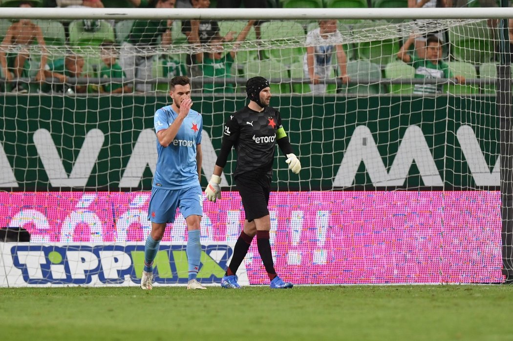 Gólman Ondřej Kolář loví balon ze sítě po vlastním gólu Tarase Kačaraby (vlevo) v duelu s Ferencvárosem