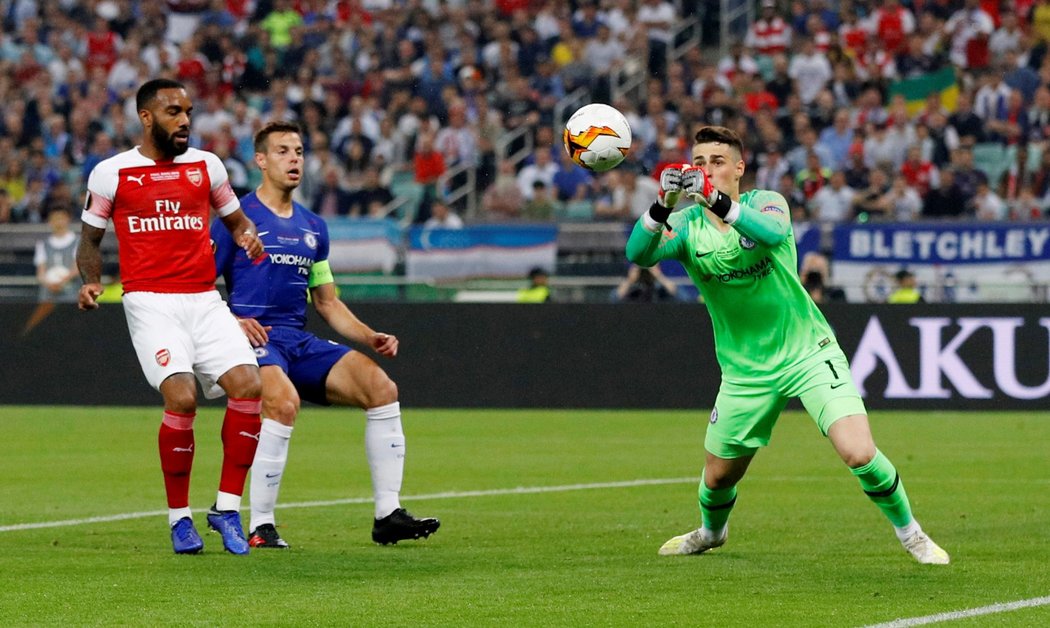 Brankář Chelsea Kepa Arrizabalaga nejistě vyráží centr před Alexandrem Lacazettem a Cesarem Azpilicuetou