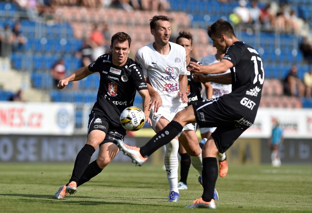 Adam Gabriel odkopává míč před Liborem Kozákem ze Slovácka. Bek Hradce později schytal červenou kartu