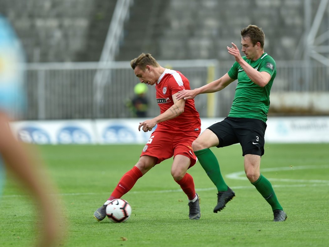 Brněnský obránce Jakub Šural odehrává míče před Romanem Květem z Příbrami