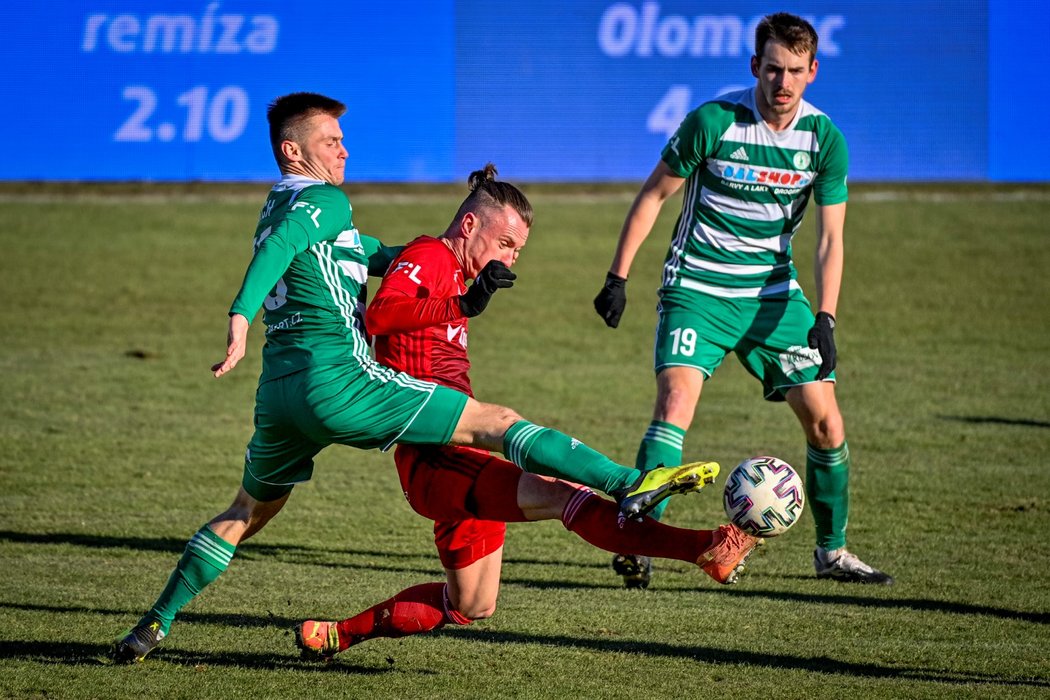 Olomouckého Martina Nešpora (v červeném) brání Daniel Krch z Bohemians. Všemu přihlíží v pozadí Roman Květ