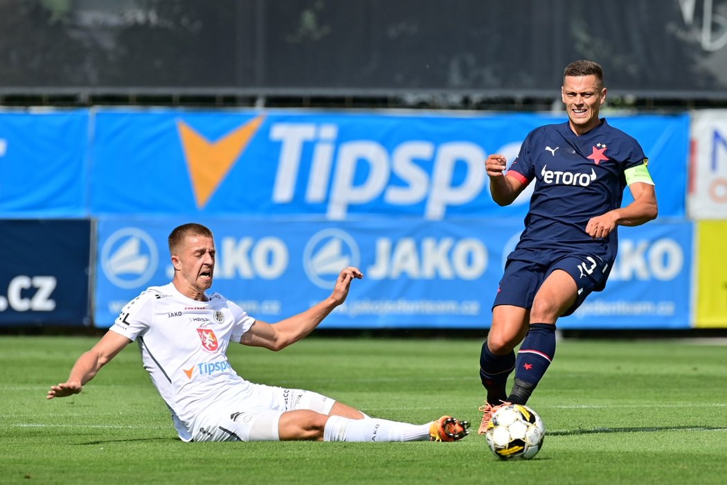 Slávistický kapitán Tomáš Holeš odehrává míč před dojíždějícím protihráčem