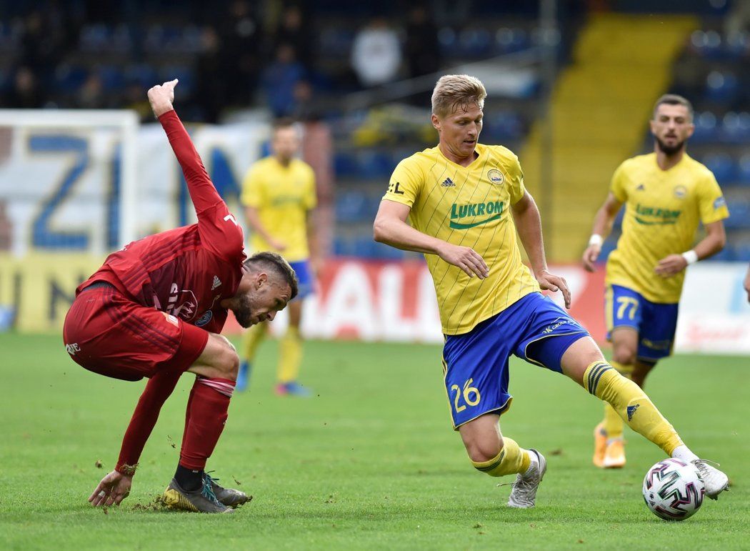 Zlínský stoper Václav Procházka drží balon před olomouckým záložníkem Lukášem Greššákem