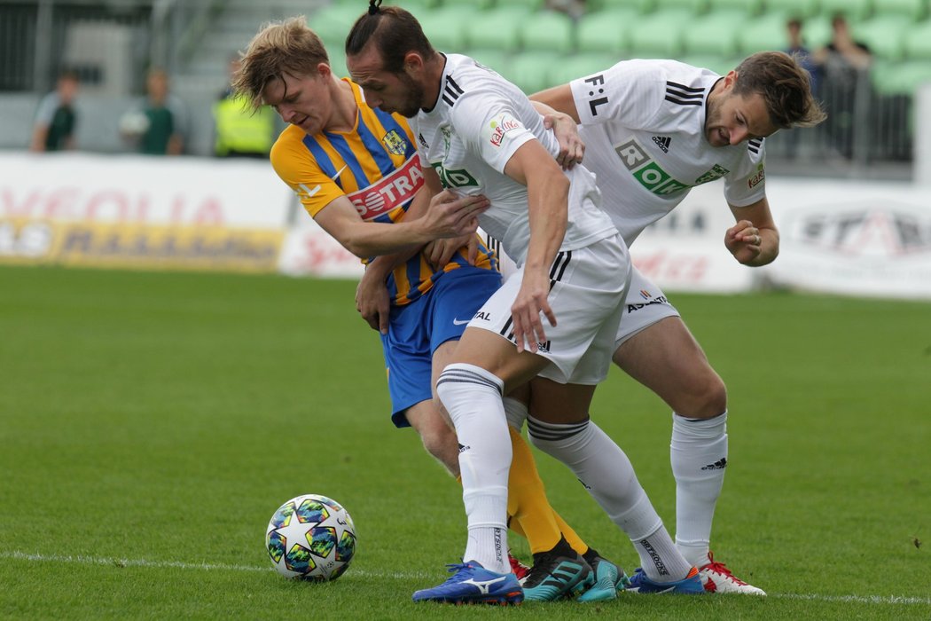 Opavský Pavel Šulc bojuje o míč s dvojicí karvinských fotbalistů Stevenem Petkovem a Markem Hanouskem