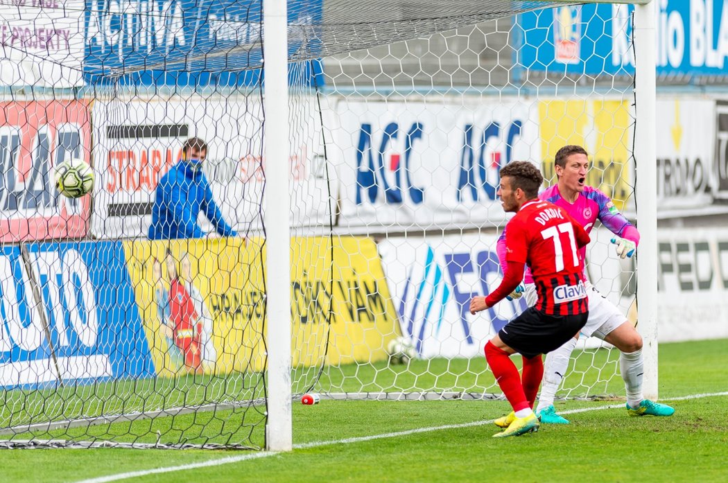 Opavský Bojan Dordič posílá míč za teplického brankáře Tomáše Grigara