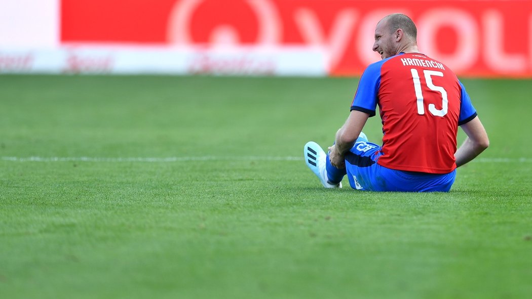 Michael Krmenčík sedí na trávníku poté, co si v zápase s Opavou přivodil zranění