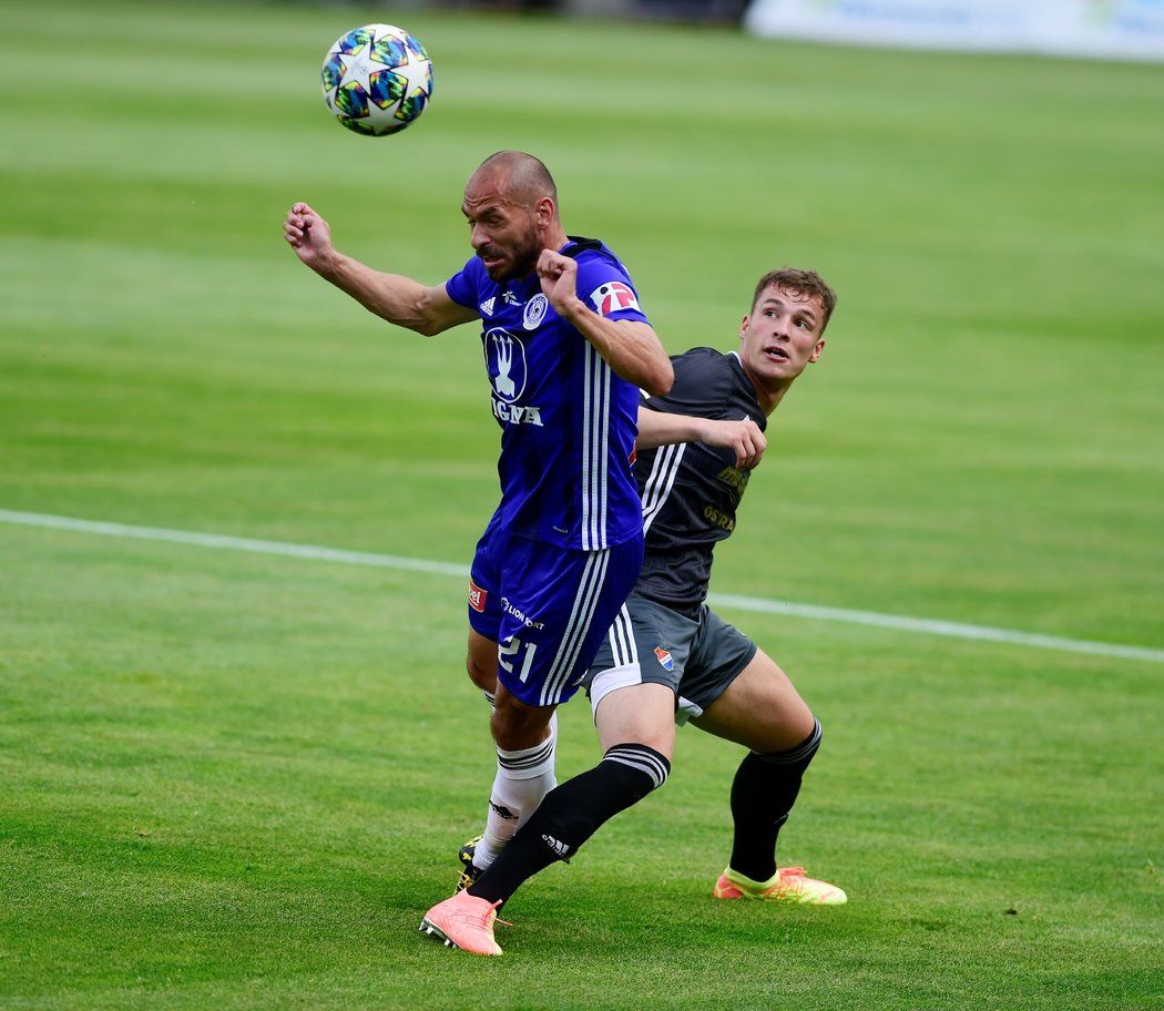 Ondřej Šašinka z Baníku Ostrava se nedostal k míči dřív než olomoucký obránce Michal Vepřek, který se chystá hlavičkovat