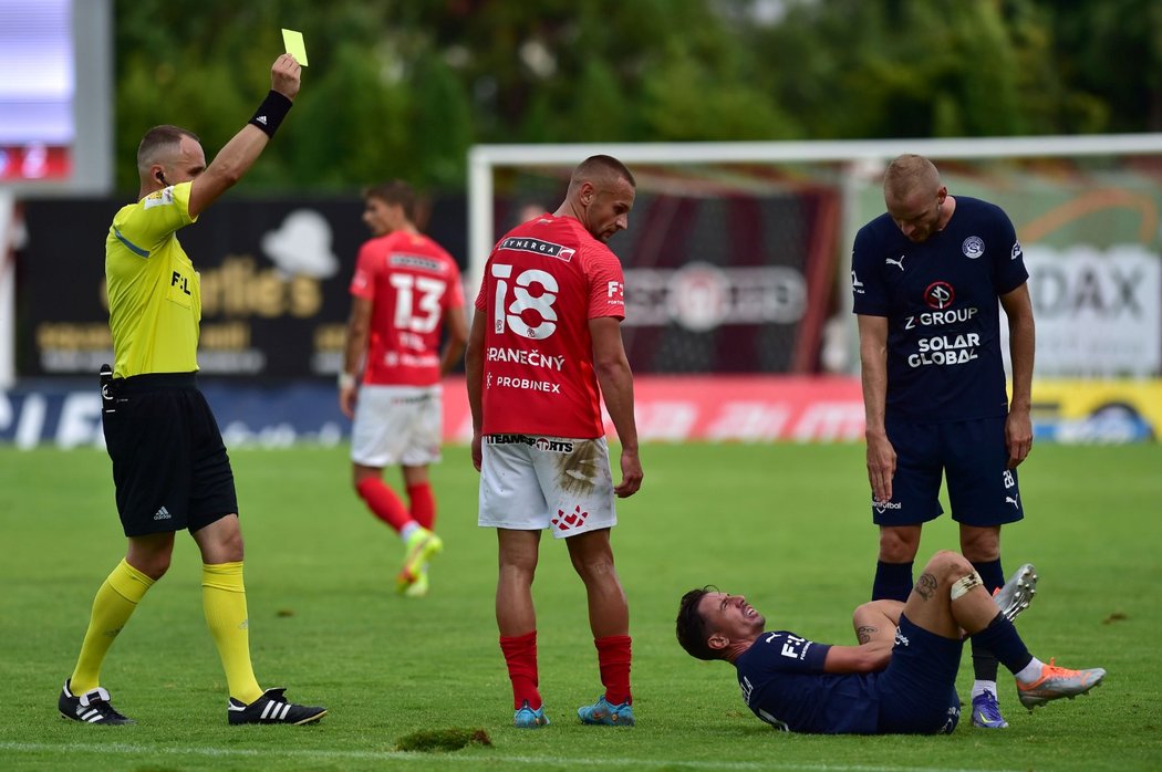 Denis Granečný z Brna (uprostřed)dostává žlutou kartu. Zprava Vlastimil Daníček ze Slovácka a faulovaný Milan Petržela ze Slovácka