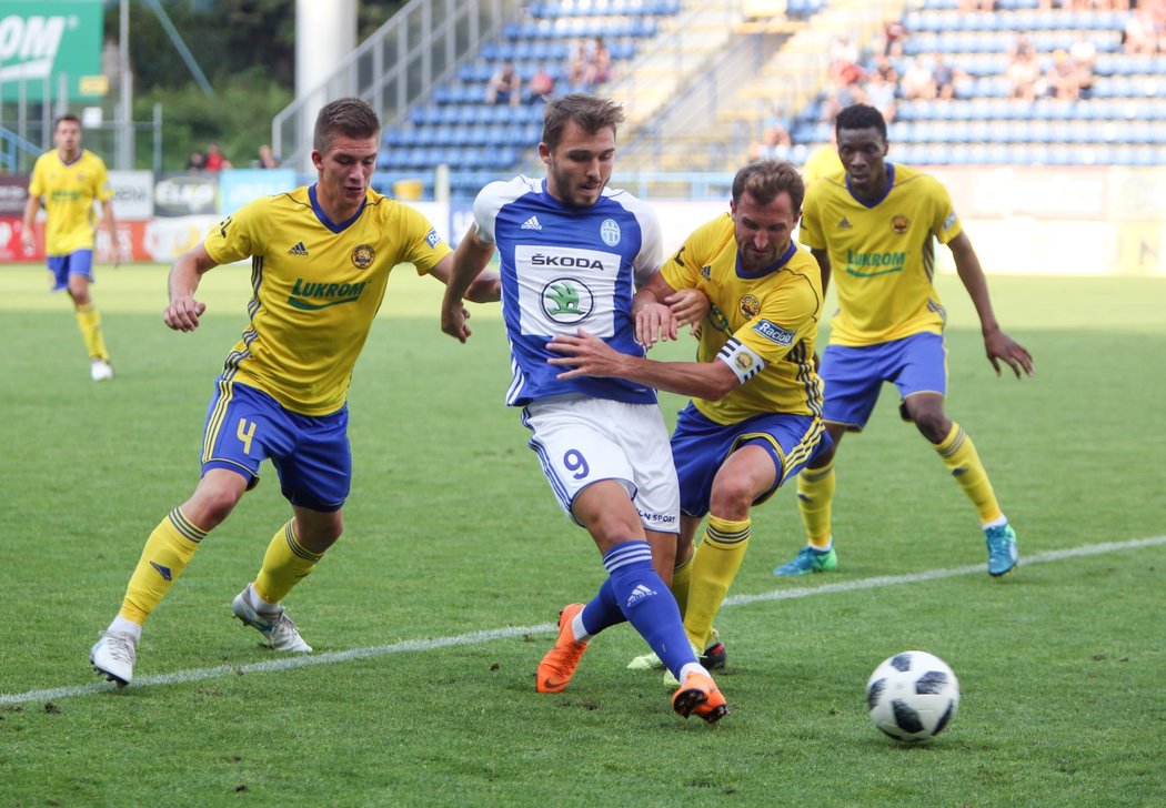Boleslavský záložník Tomáš Ladra odehrává míč před atakujícími protihráči ze Zlína