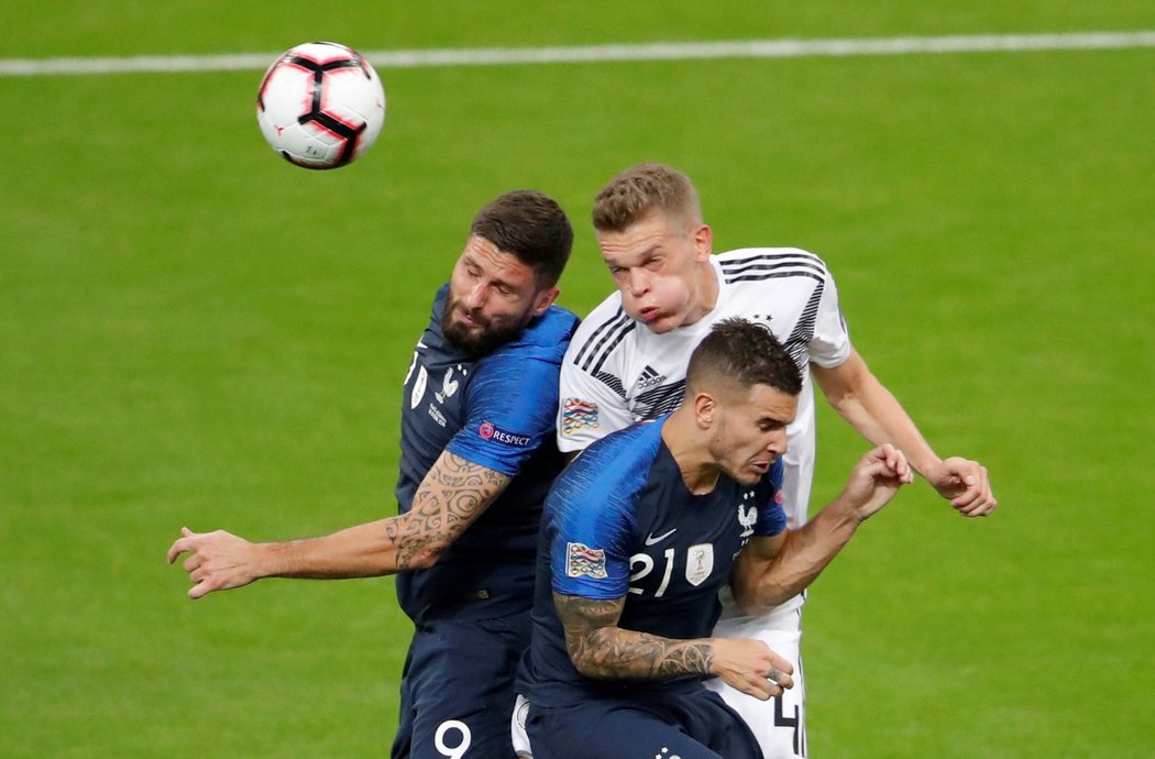 Němec Matthias Ginter se snaží dostat k míči přes francouzskou dvojici Olivier Giroud Lucas Hernandez