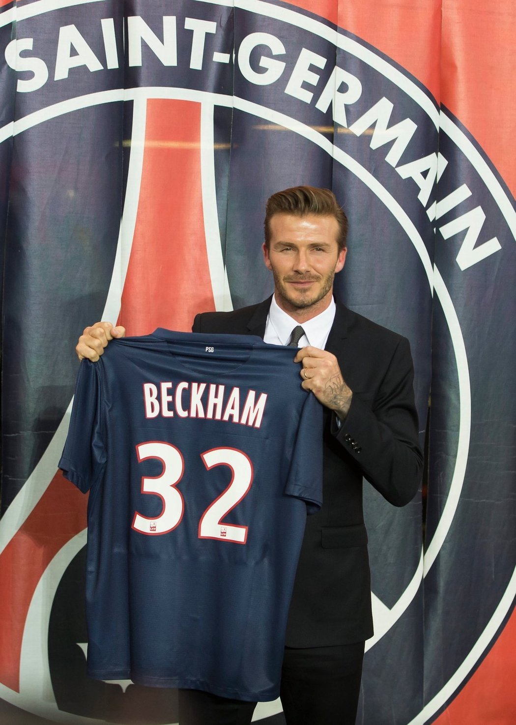 David Beckham pózuje s dresem svého nového klubu, Paris St. Germain