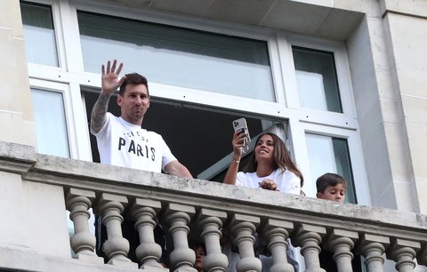 Lionel Messi s manželkou Antonelou mává fanouškům z balkonu svého hotelu v Paříži