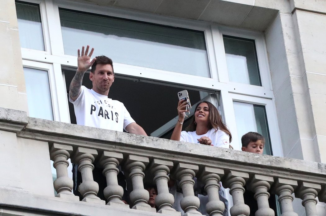 Lionel Messi s manželkou Antonelou mává fanouškům z balkonu svého hotelu v Paříži