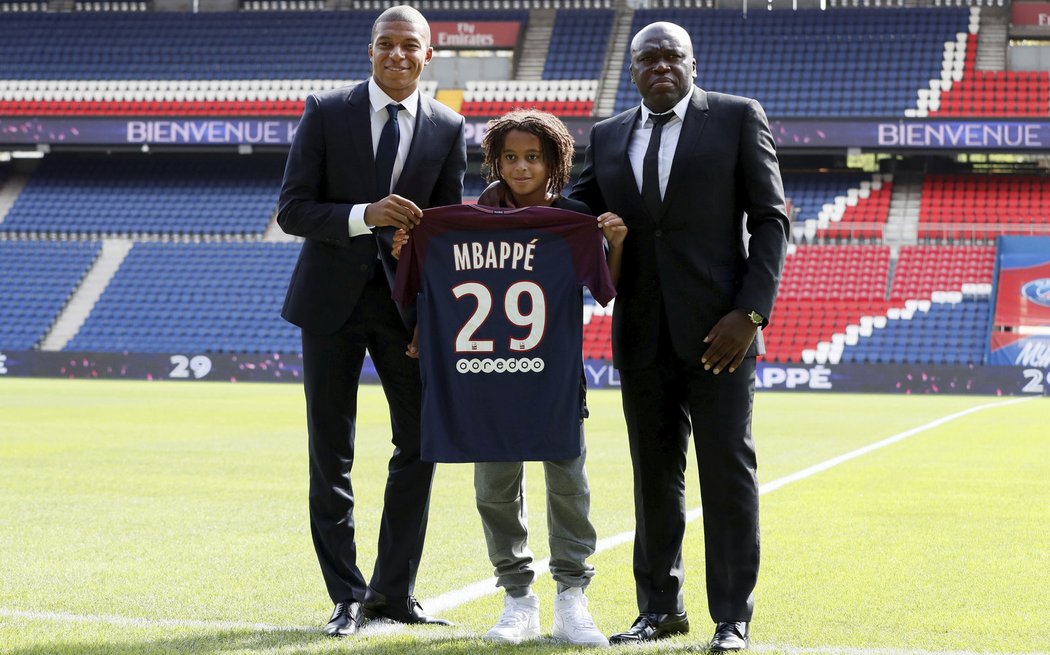 Kylian Mbappé s bratrem Ethanem a otcem Wilfriedem pózují s dresem PSG s číslem 29