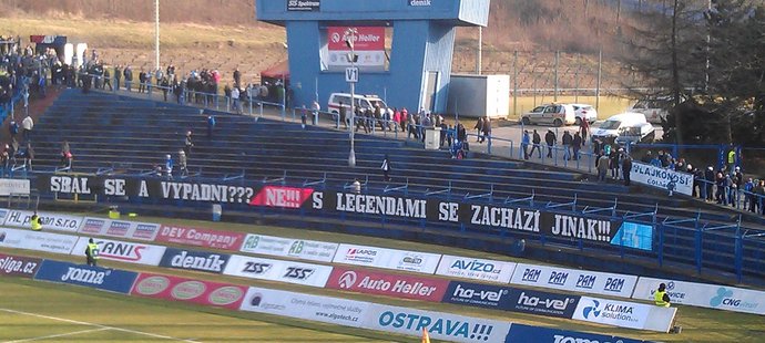 Prázdný ochoz za brankou a transparent baníkovských fanoušků se vzkazem vedení klubu