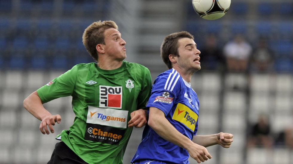 Jan Kopic (vlevo) bojuje o míč s olomouckým Radim Nepožitkem
