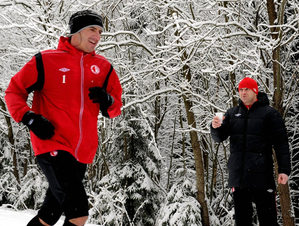 Gólman Slavie Kamil Čontofalský na soustředění v Krkonoších probíhá okolo Stanislava Vlčka