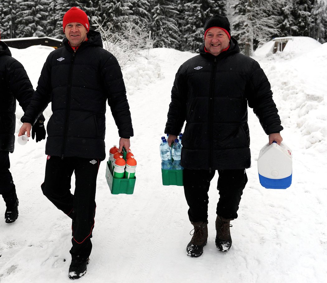Stanislav Vlček (vlevo) v doprovodu maséra Jiřího Tenkwitze nesou pití slávistickým hráčům během soustředění v Krkonoších