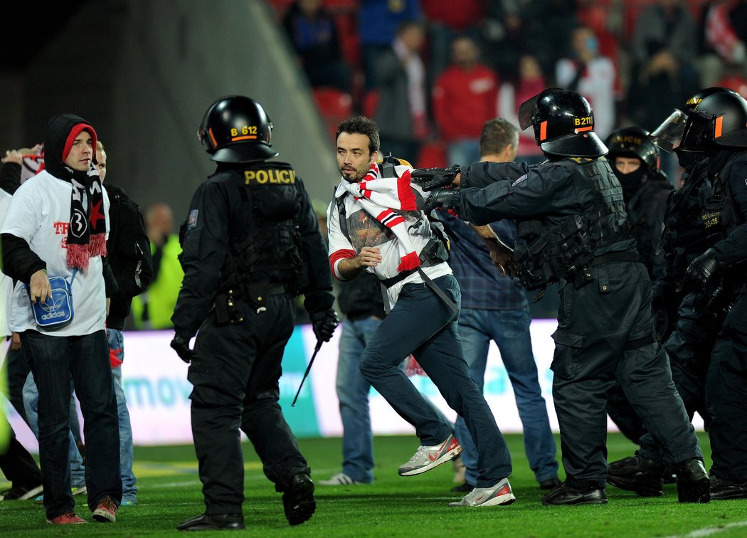 Fanoušky Slavie, kteří po derby &#34;S&#34; vtrhli na plochu, museli kroti policejní těžkooděnci