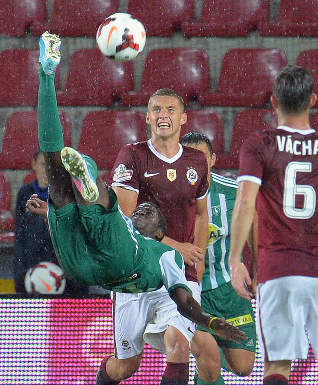 Moustapha Ndiaye z Bohemians se pokusil v derby na Letné o akrobatické zakončení. To sleduje sparťan  Pavel Kadeřábek (vzadu). Sparta vyhrála derby 2:1