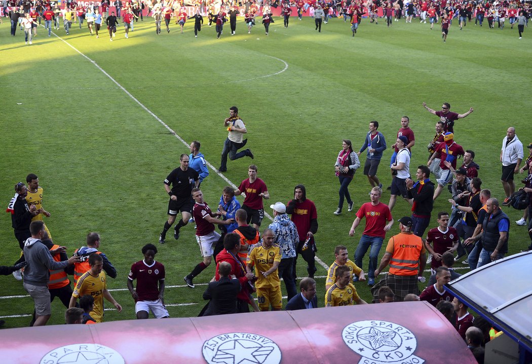 Fotbalisté Sparty a Jihlavy prchají před slavícími fanoušky do útrob stadionu po konci zápasu s Jihlavou