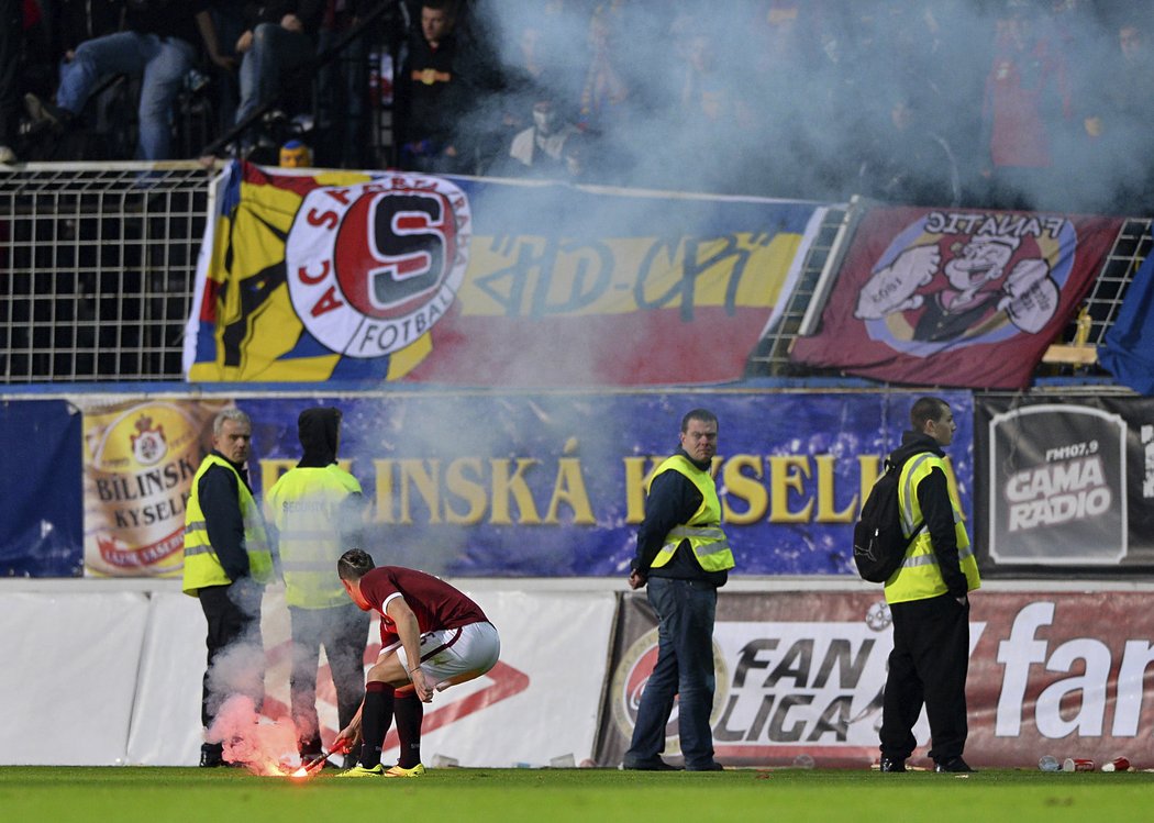 Lukáš Vácha uklízí světlici, která přiletěla na hřiště ze sparťanského kotle