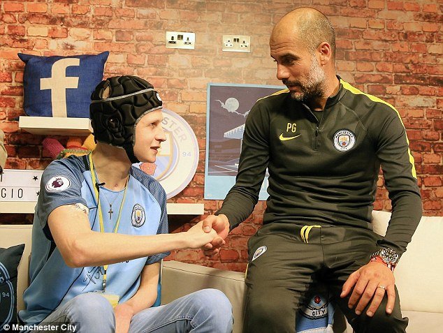 Podavač míčů Elliott Fernandez-Sanz na stadionu Manchesteru City s trenérem Pepem Guardiolou. 