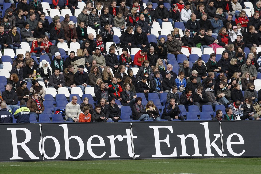 Lidé v hledišti fotbalového stadionu Hannoveru při posledním rozloučení s brankářem Robertem Enkem.