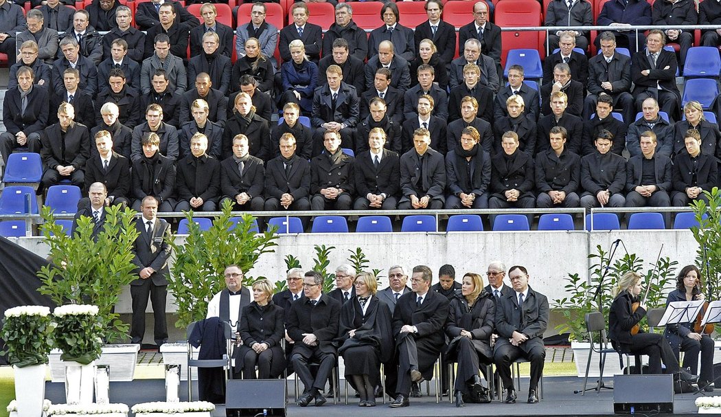 Fotbalová reprezentace Německa (nad pódiem) zažívá při pohřbu spolehráče Roberta Enkeho smutné chvíle.