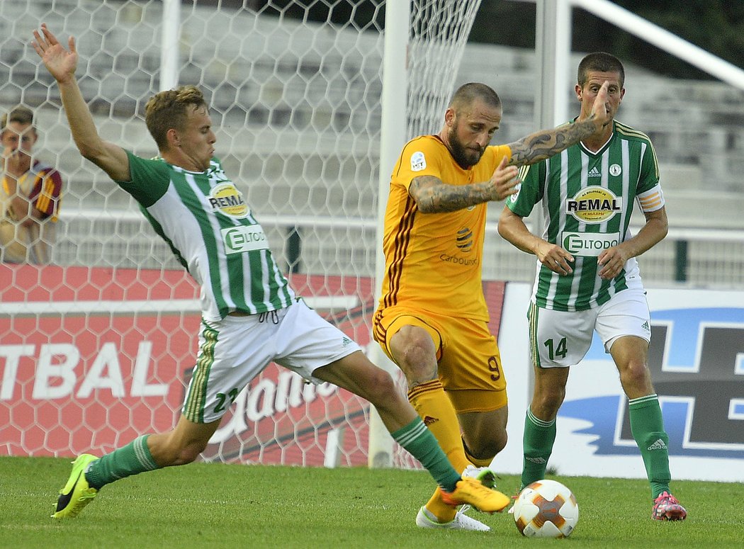 Martin Hašek (vlevo) z Bohemians 1905 se snaží obrat o míč Jana Holendu z Dukly, vpravo přihlíží Michal Šmíd