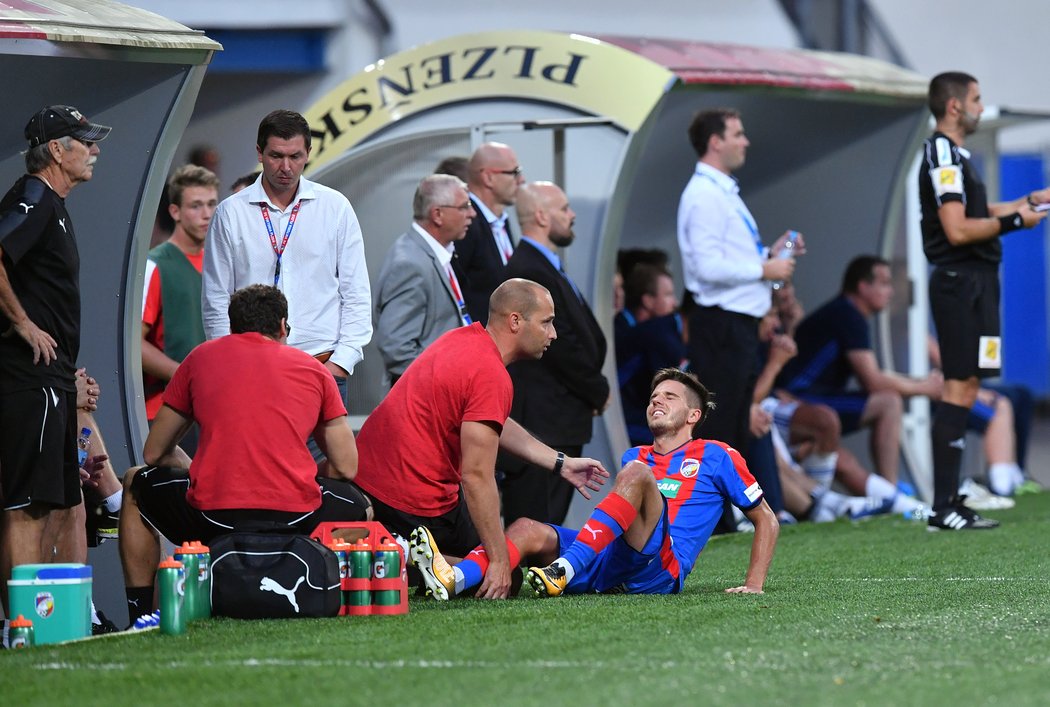 Aleš Čermák s bolestivou grimasou před lavičkou Plzně v zápase s Baníkem