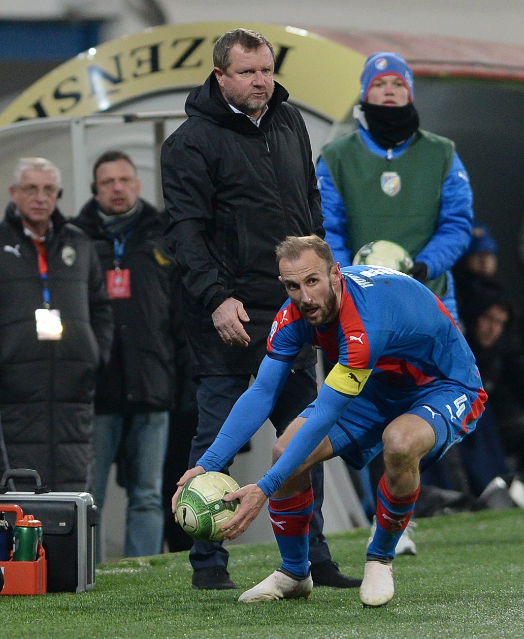 Roman Hubník snažící se rychle rozehrát v závěrečném tlaku Plzně. V pozadí stojící kouč Viktorie Pavel Vrba