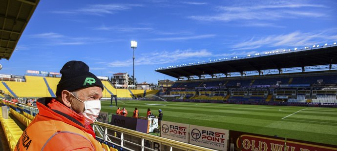 Pořadatel s rouškou v prázdném hledišti stadionu v Parmě, kde se nakonec hrál zápas se Spalem