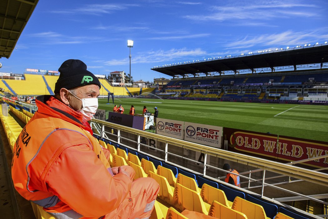 Pořadatel s rouškou v prázdném hledišti stadionu v Parmě, kde se nakonec hrál zápas se Spalem