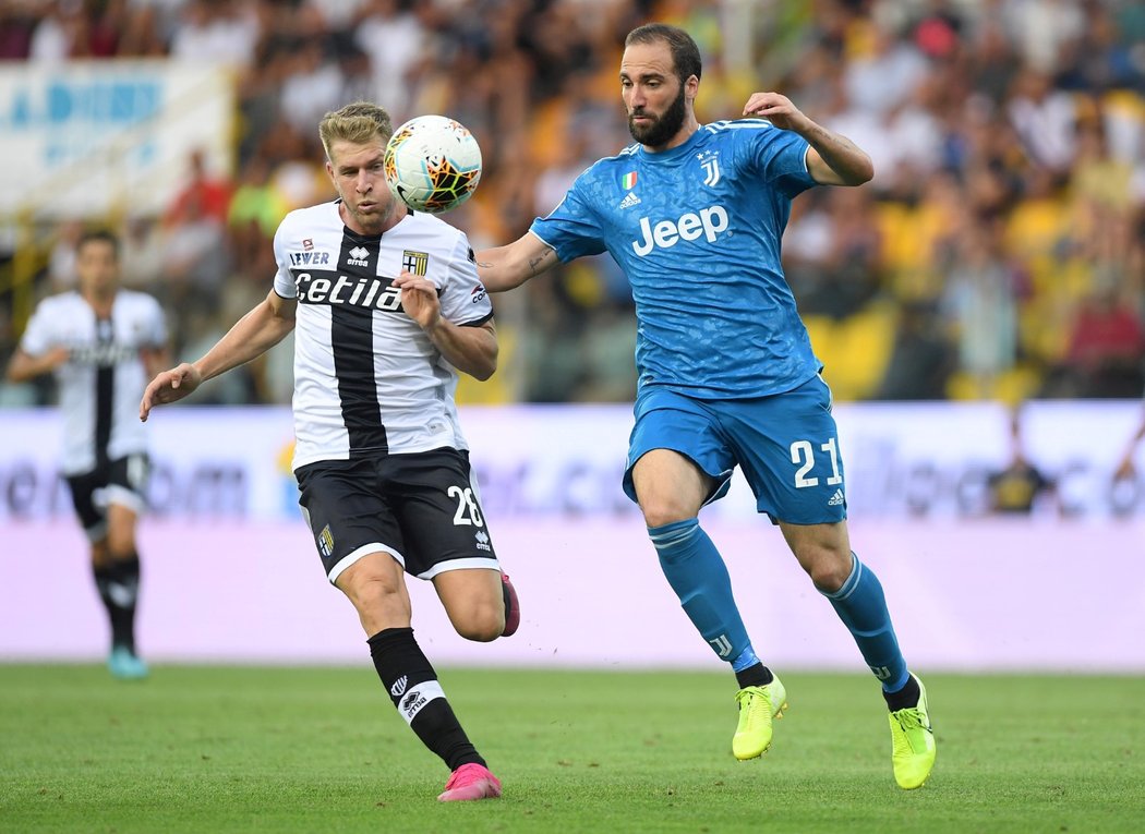 Gonzalo Higuaín z Juventusu se snaží dostat k míči dříve než obránce Parmy Riccardo Gagliolo