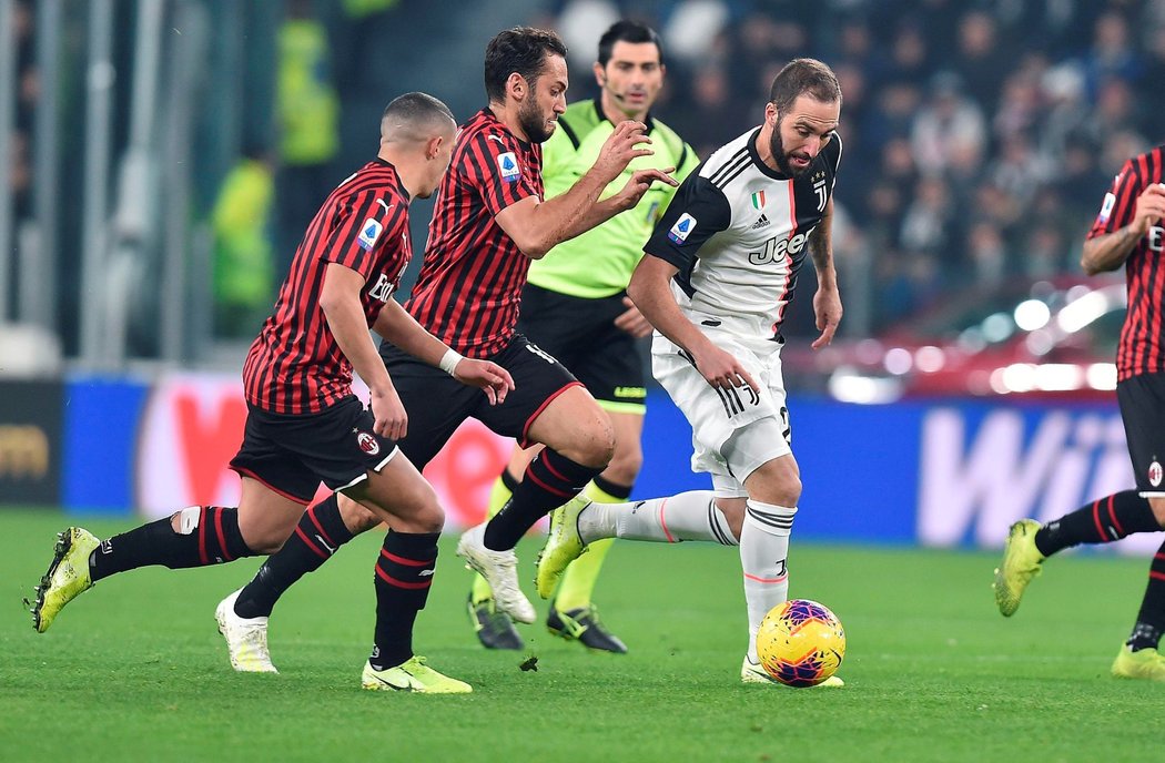 Útočník Gonzalo Higuaín uniká svýcm strážcům z AC Milán