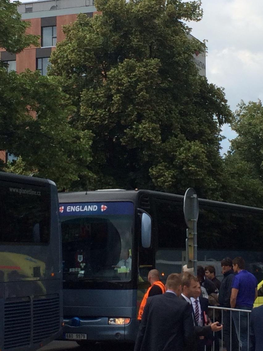 Autobus anglické jednadvacítky doráží ke stadionu, hotel je hned v pozadí, pár metrů cesty